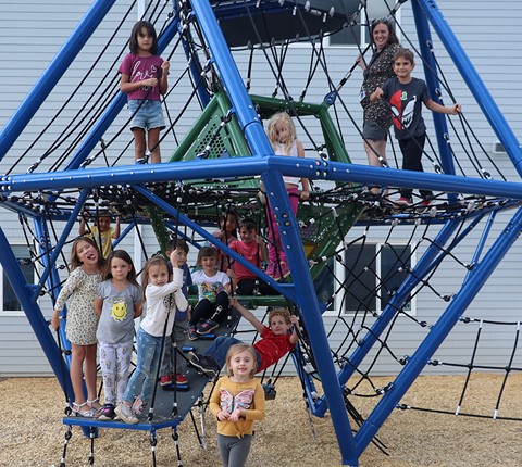 Children playing outside on a climber